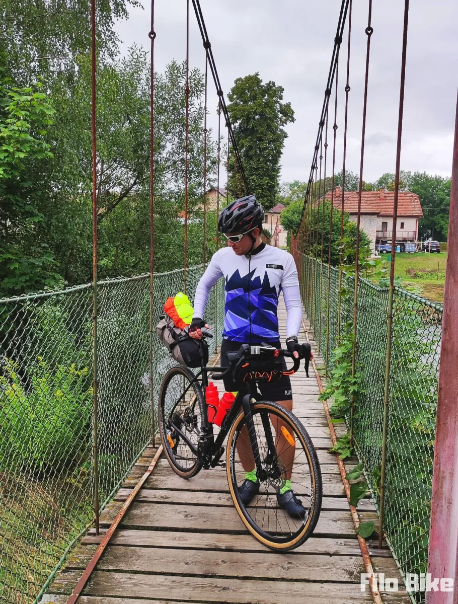 Z rowerem na kładce nad rzeką na trasie Szlaku Wokół Tatr
