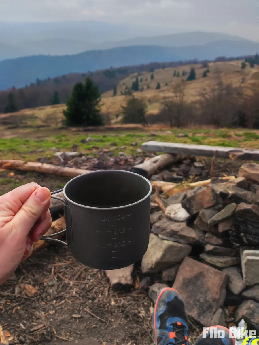Kubek tytanowy z Decathlona z kawą na tle gór