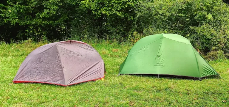 Dwa lekkie namioty na bikepacking i wyprawy rowerowe rozbite na łące.