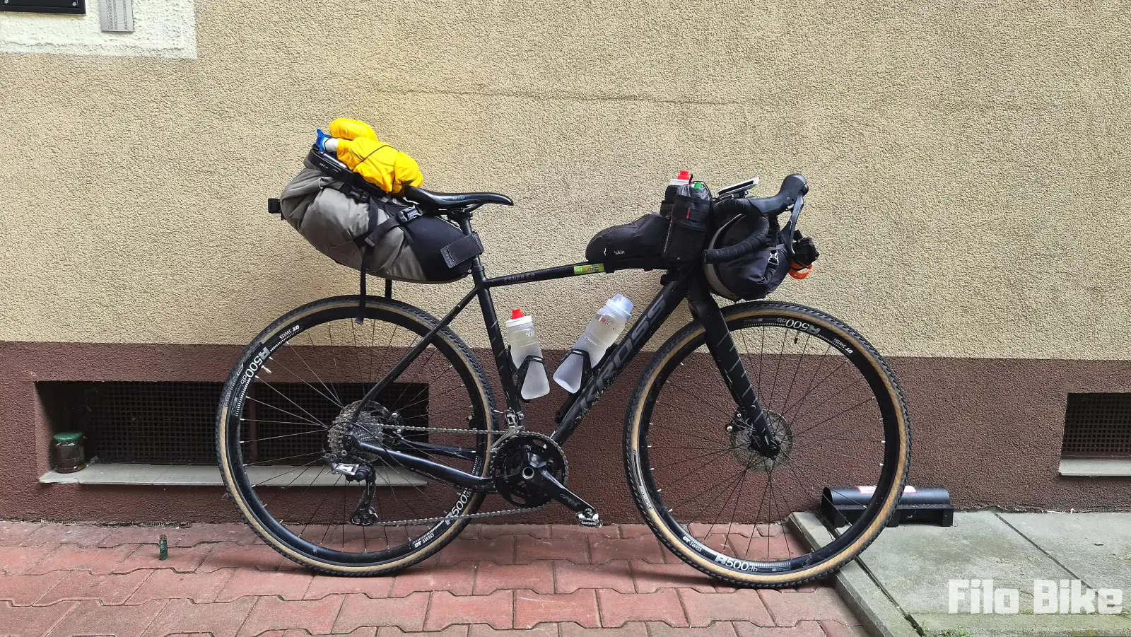 Rower gravelowy z wyposażeniem na bikepacking z namiotem