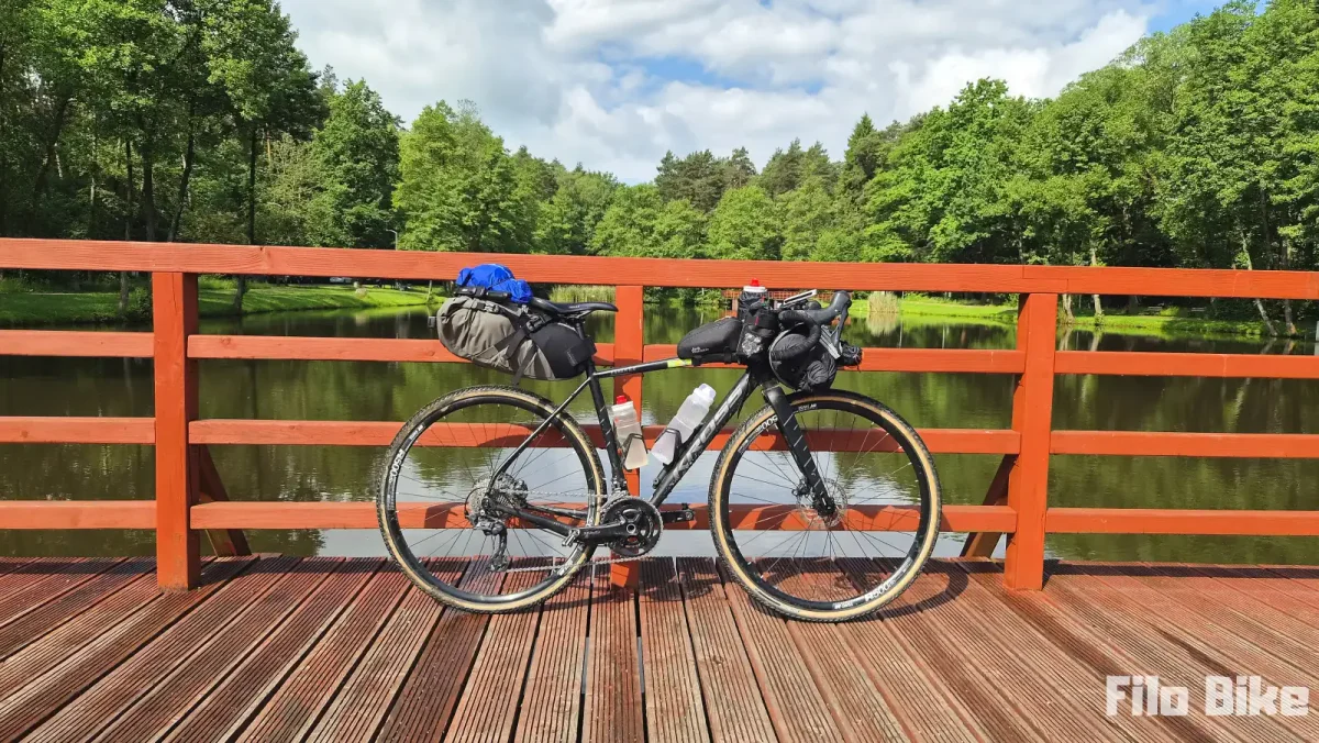 Rower gravelowy z bagażem na biwak pod namiotem w lesie